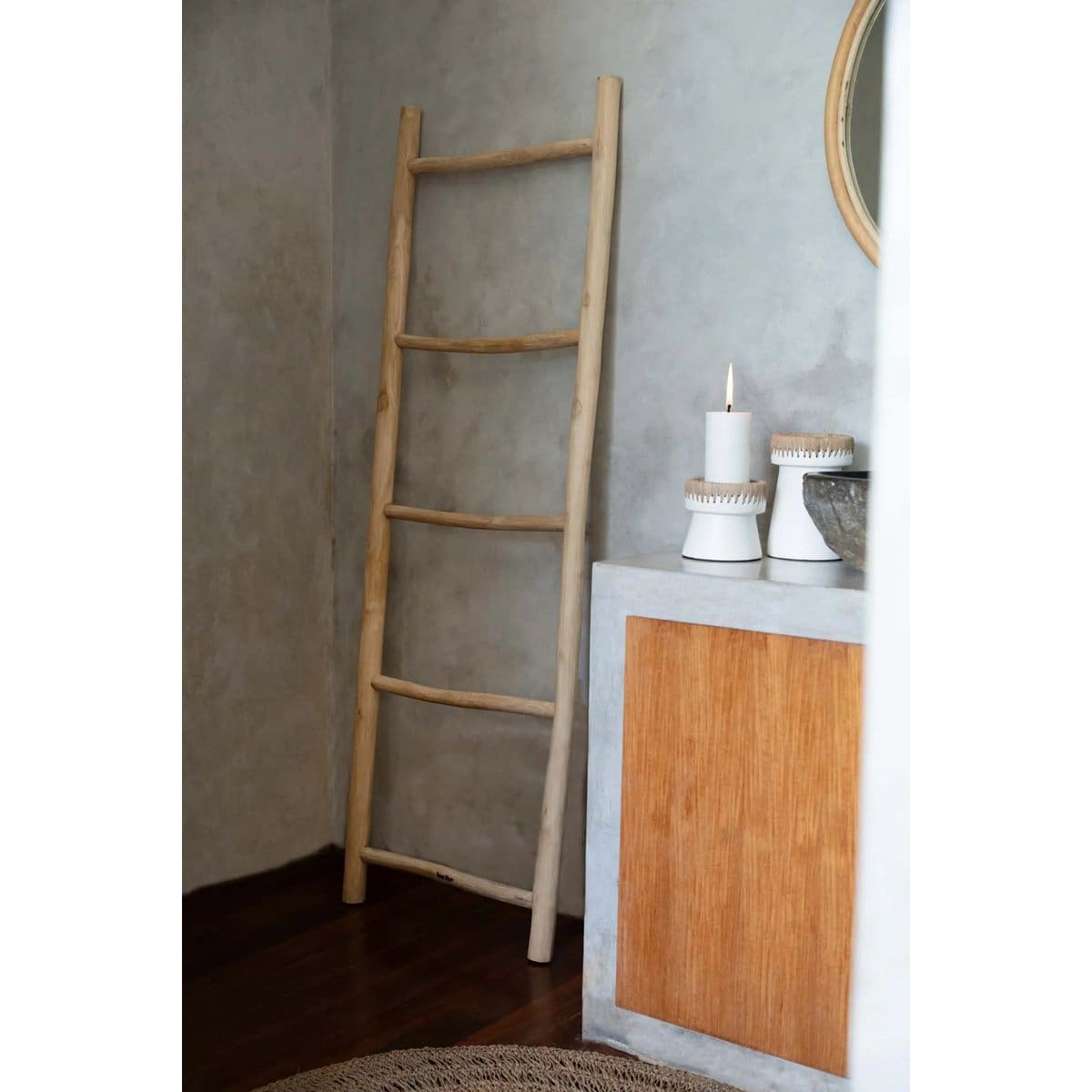 Échelle en bois avec bougie allumée sur meuble.