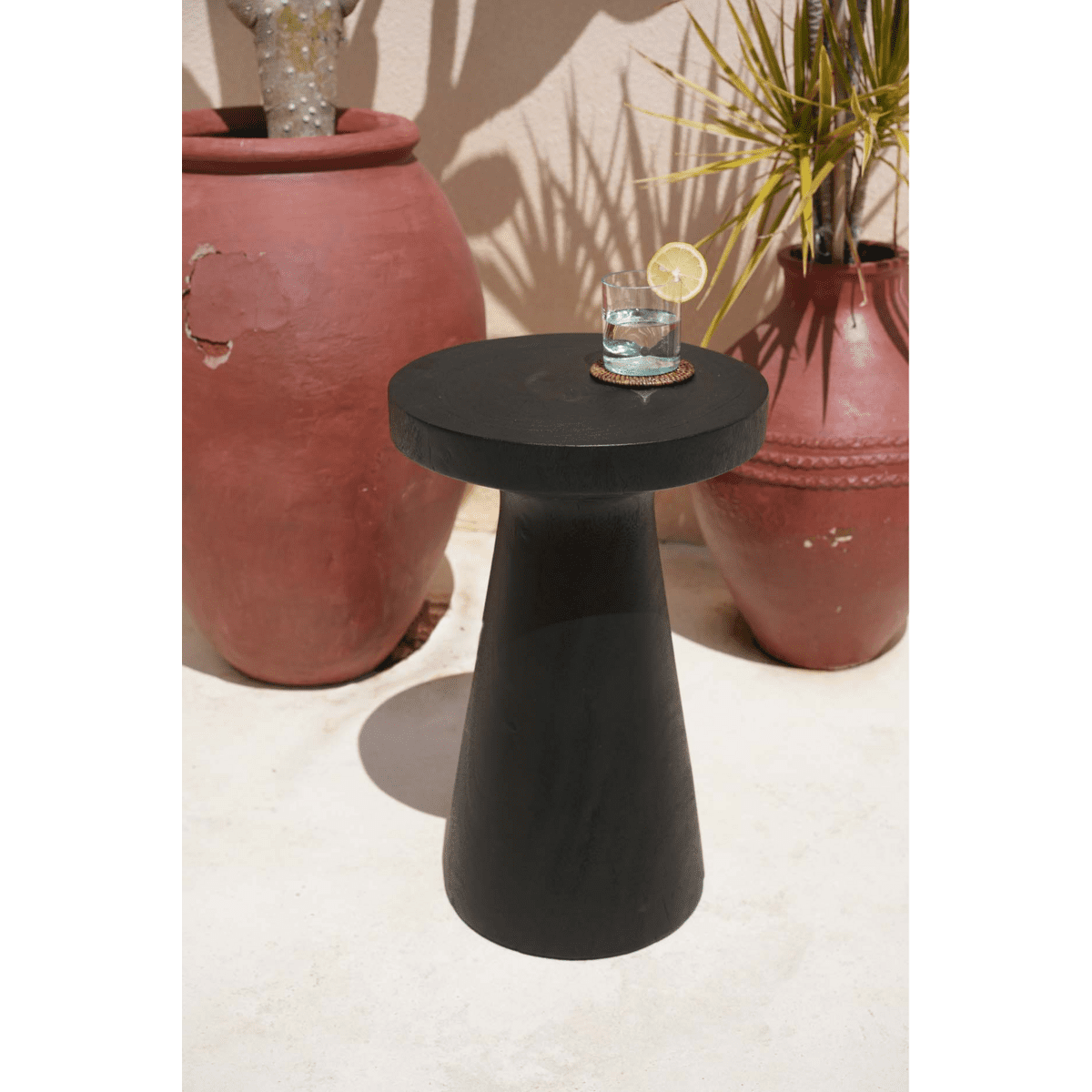 Table noire avec verre d'eau et rondelle de citron.
