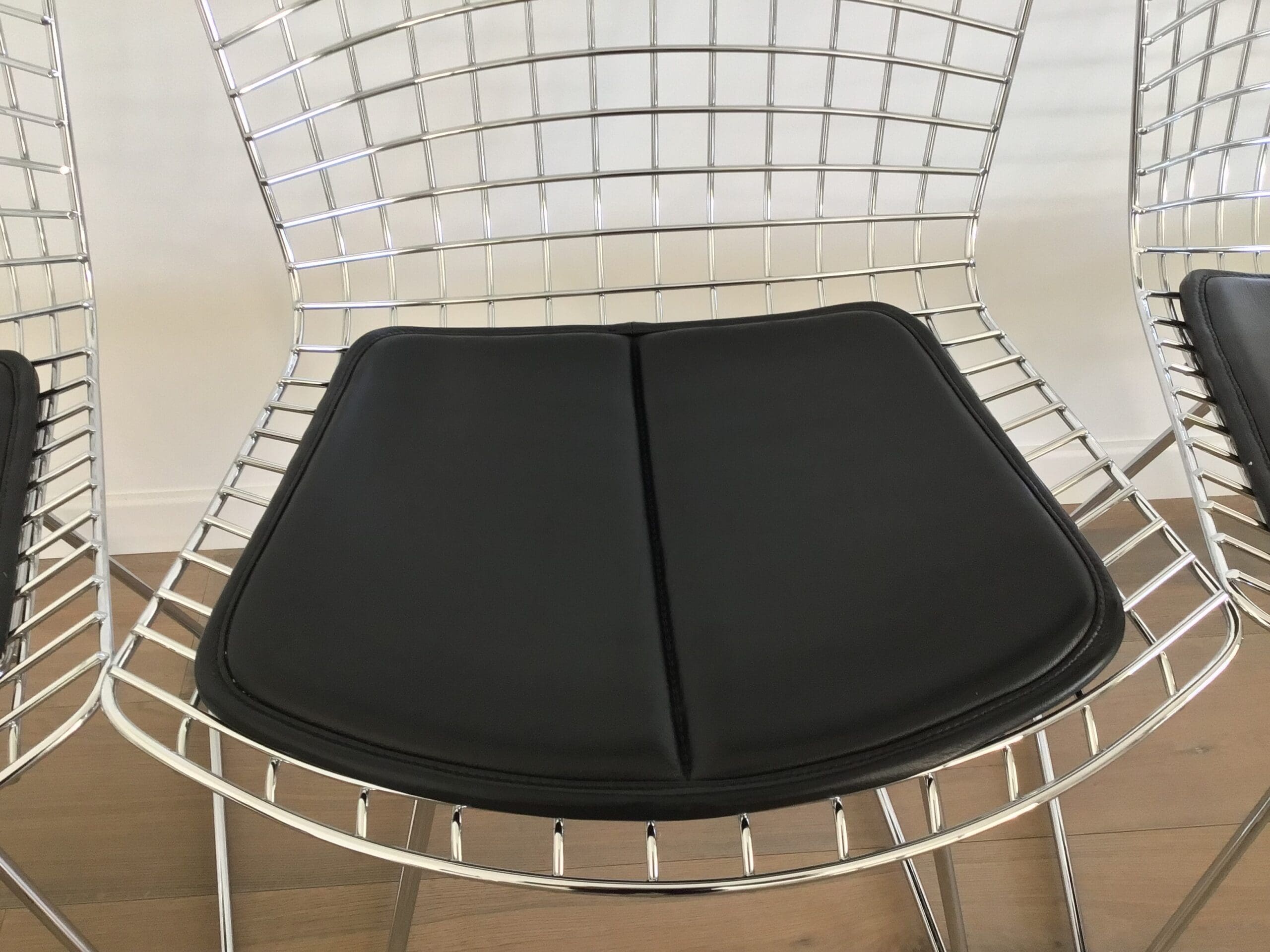 Lot de 4 chaises Bertoia chromées avec galette cuir noir – Design mid-century